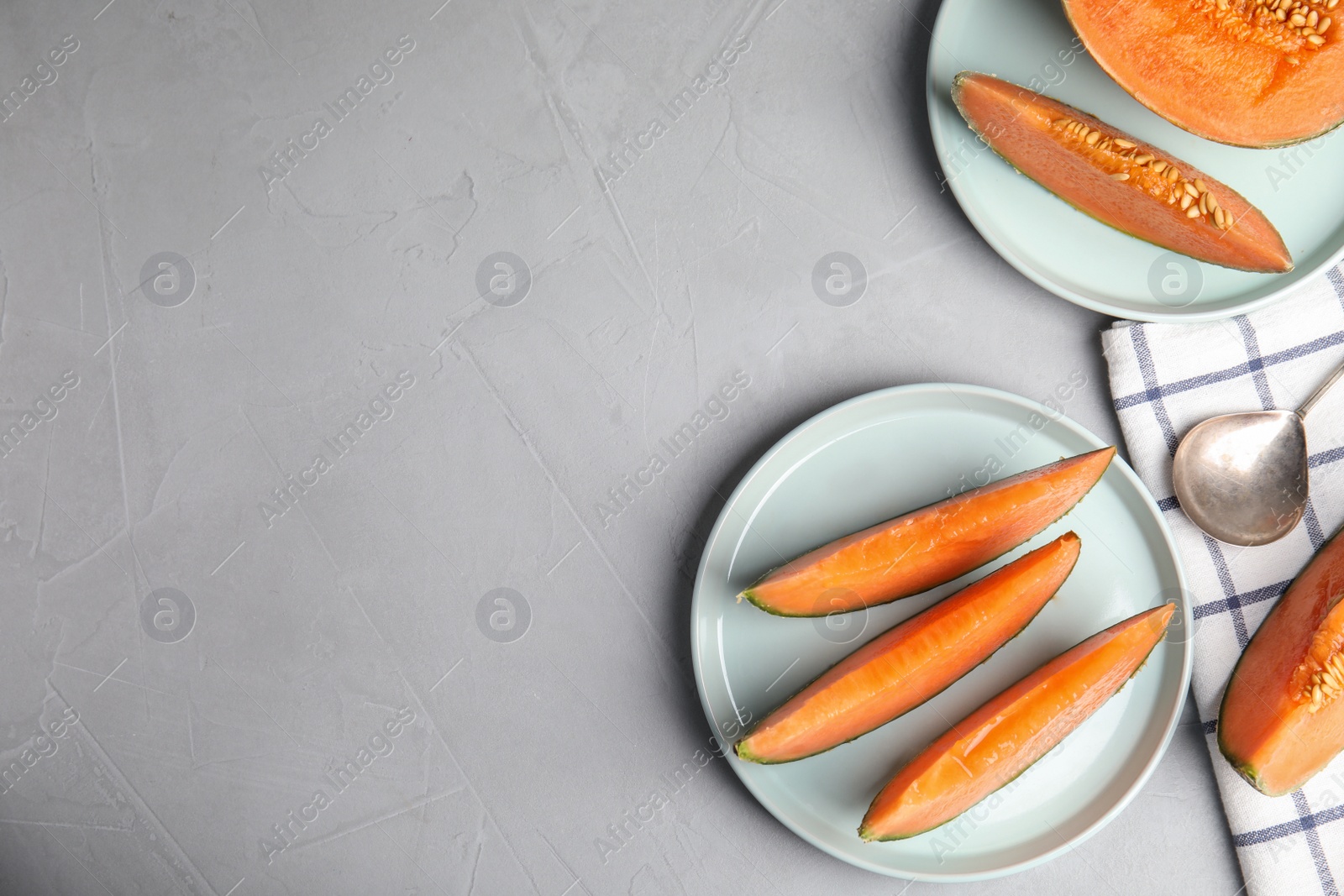 Photo of Flat lay composition with ripe cantaloupe melon on grey table. Space for text