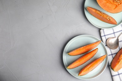 Photo of Flat lay composition with ripe cantaloupe melon on grey table. Space for text