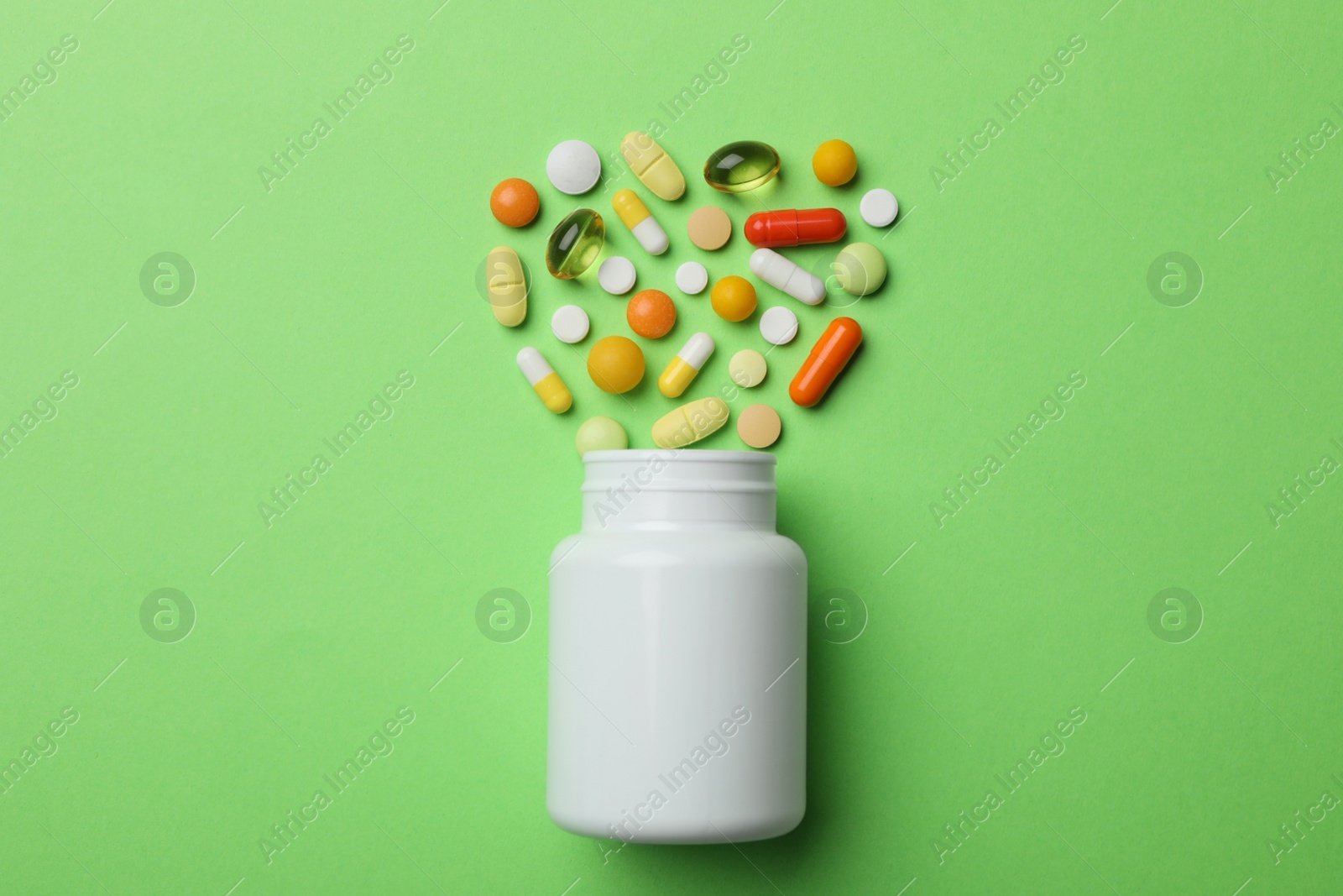 Photo of Bottle with different pills on color background, flat lay