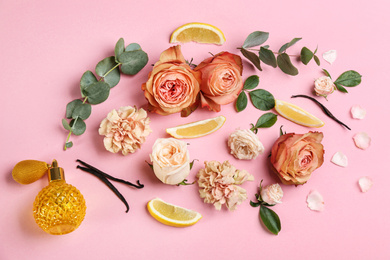 Photo of Beautiful flat lay composition with bottle of perfume, lemon and flowers on pink background