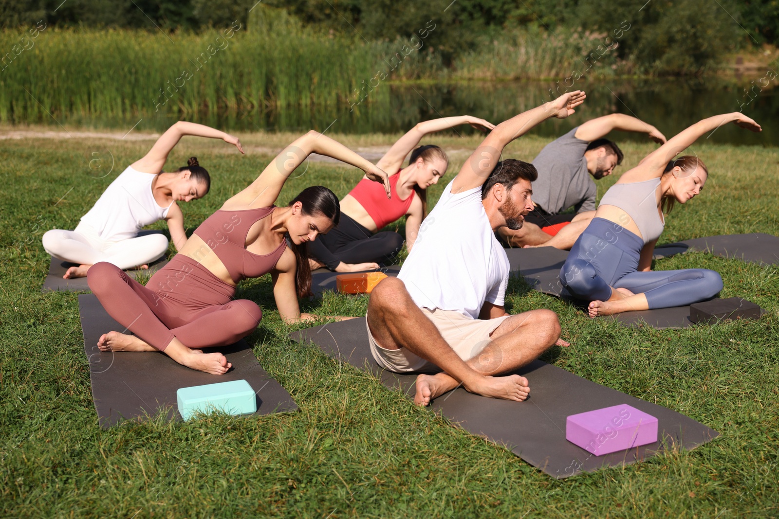 Photo of Group of people practicing yoga on mats outdoors