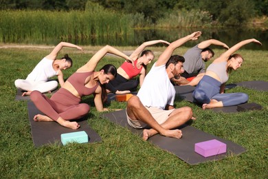 Group of people practicing yoga on mats outdoors