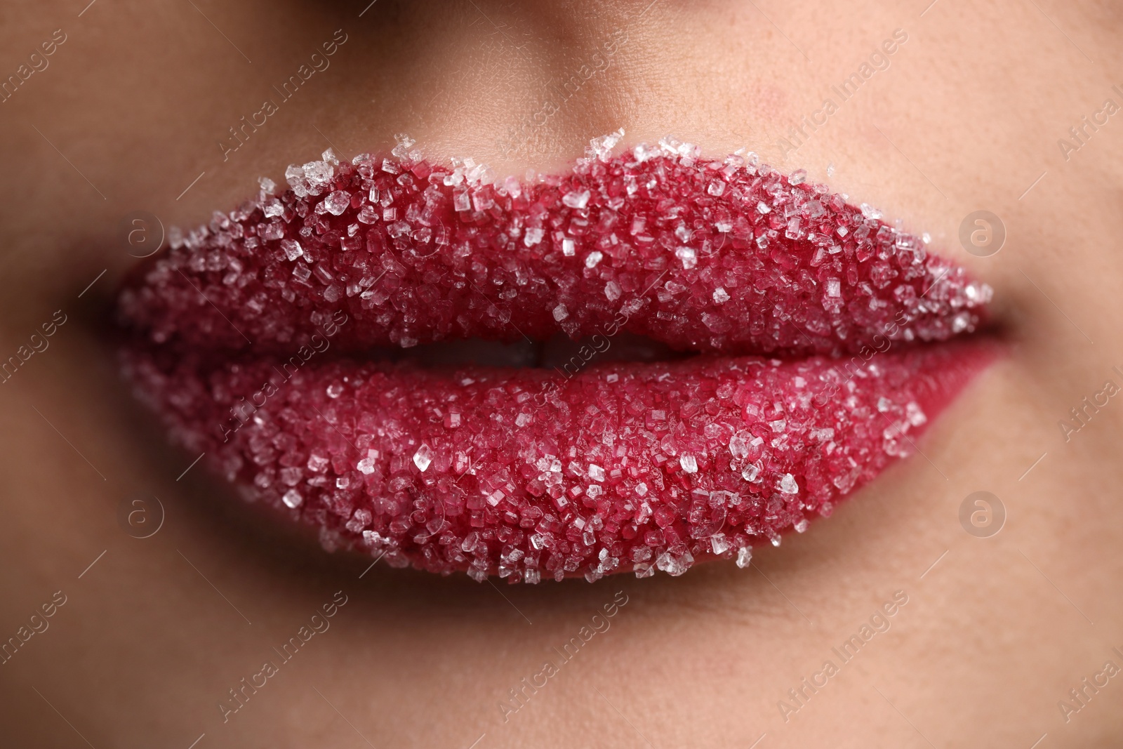 Photo of Young woman with beautiful lips covered in sugar, closeup