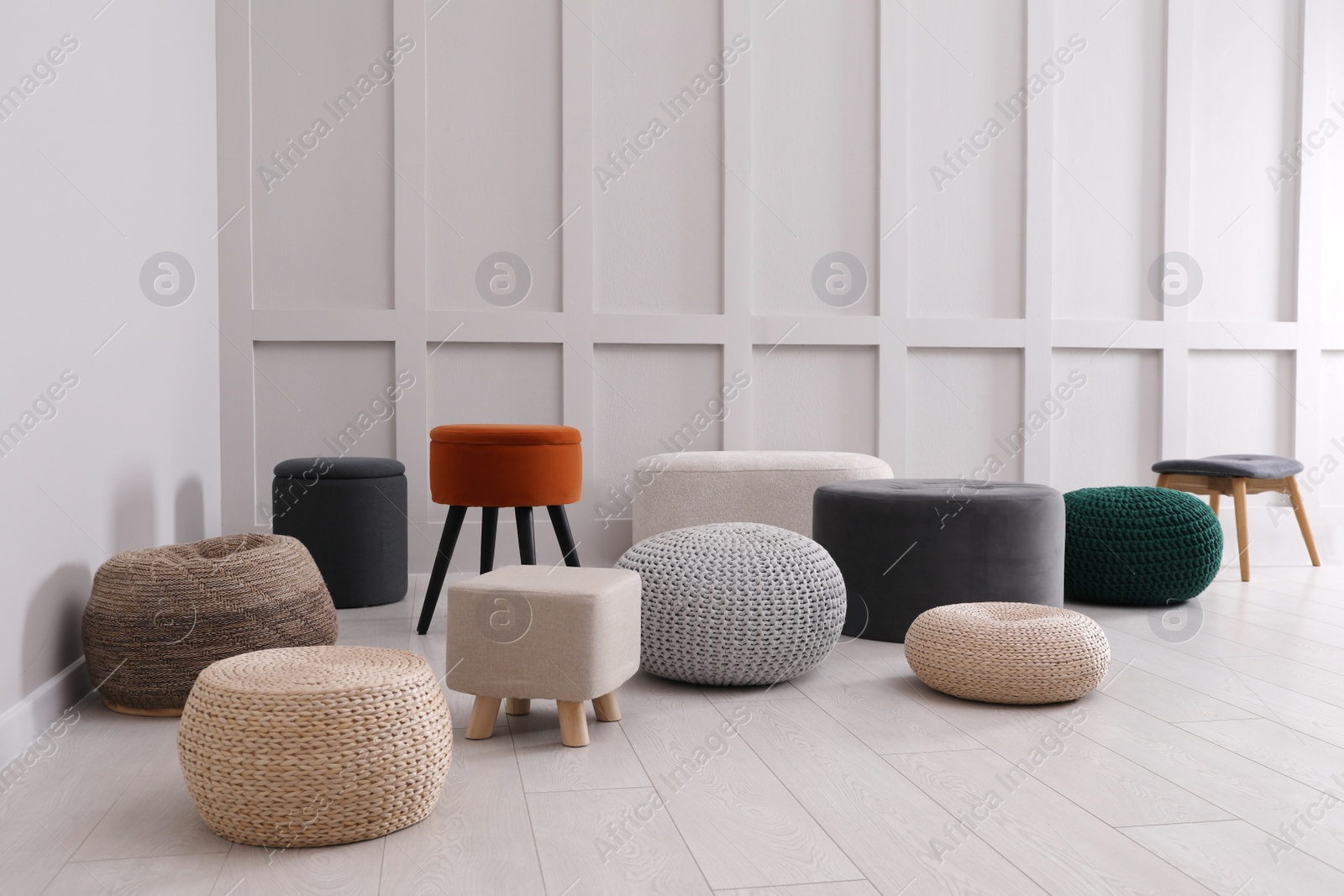 Photo of Different stylish poufs and ottomans in room