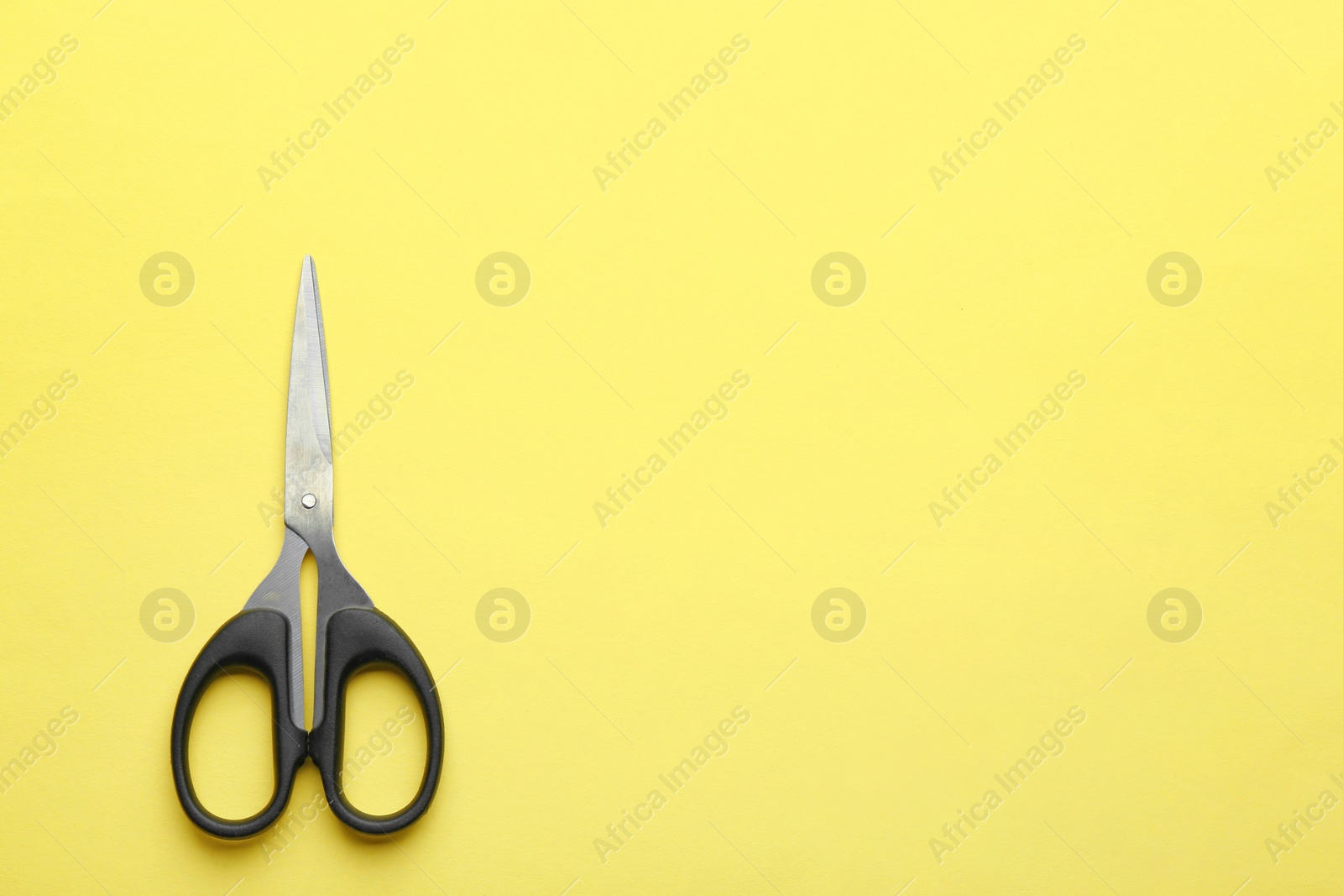 Photo of Pair of sharp scissors on color background, top view. Space for text