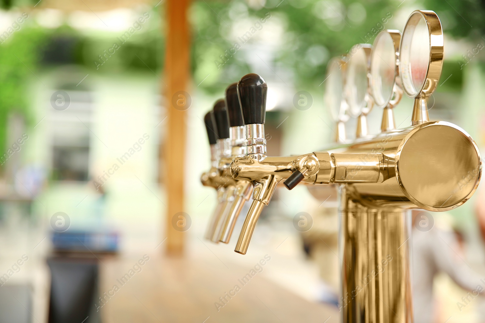 Photo of Bar counter with draft beer taps in open-air cafe