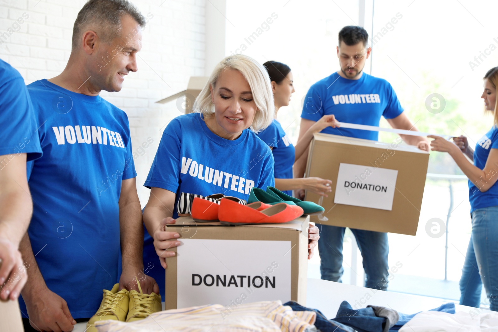 Photo of Team of volunteers collecting donations in boxes indoors