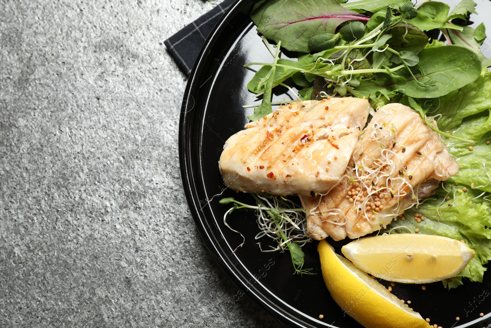 Photo of Tasty grilled fish on grey table, top view