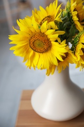 Photo of Bouquet of beautiful sunflowers on table indoors, closeup