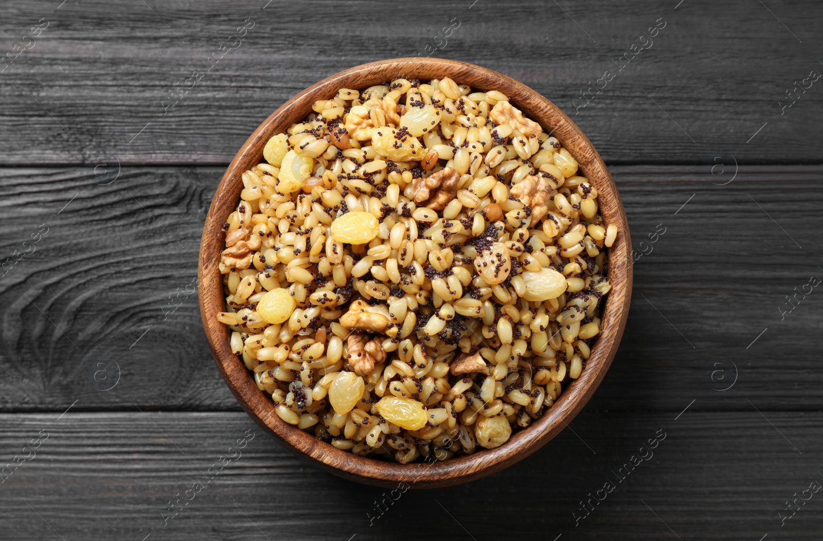 Photo of Traditional Christmas slavic dish kutia on black wooden table, top view