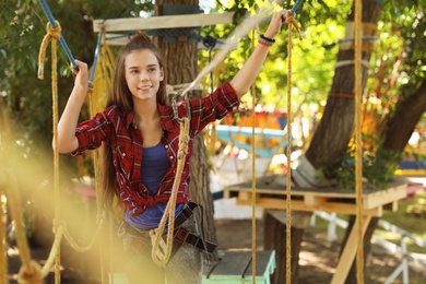 Teenage girl climbing in adventure park. Summer camp