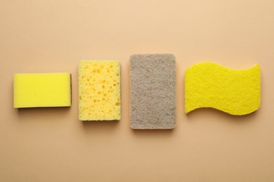 Photo of New sponges on beige background, flat lay