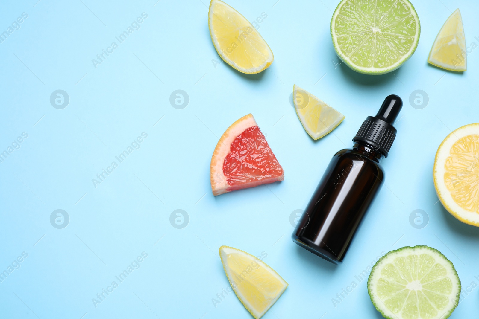 Photo of Flat lay composition with citrus essential oil on light blue background. Space for text