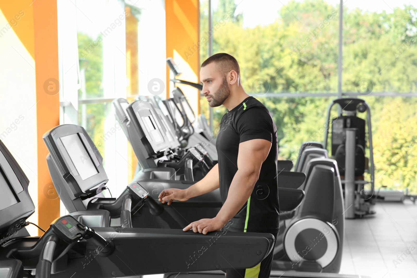 Photo of Strong young man on treadmill in gym