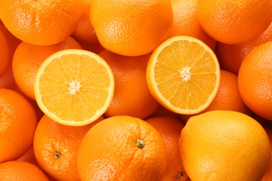 Photo of Cut and whole fresh ripe oranges as background, top view