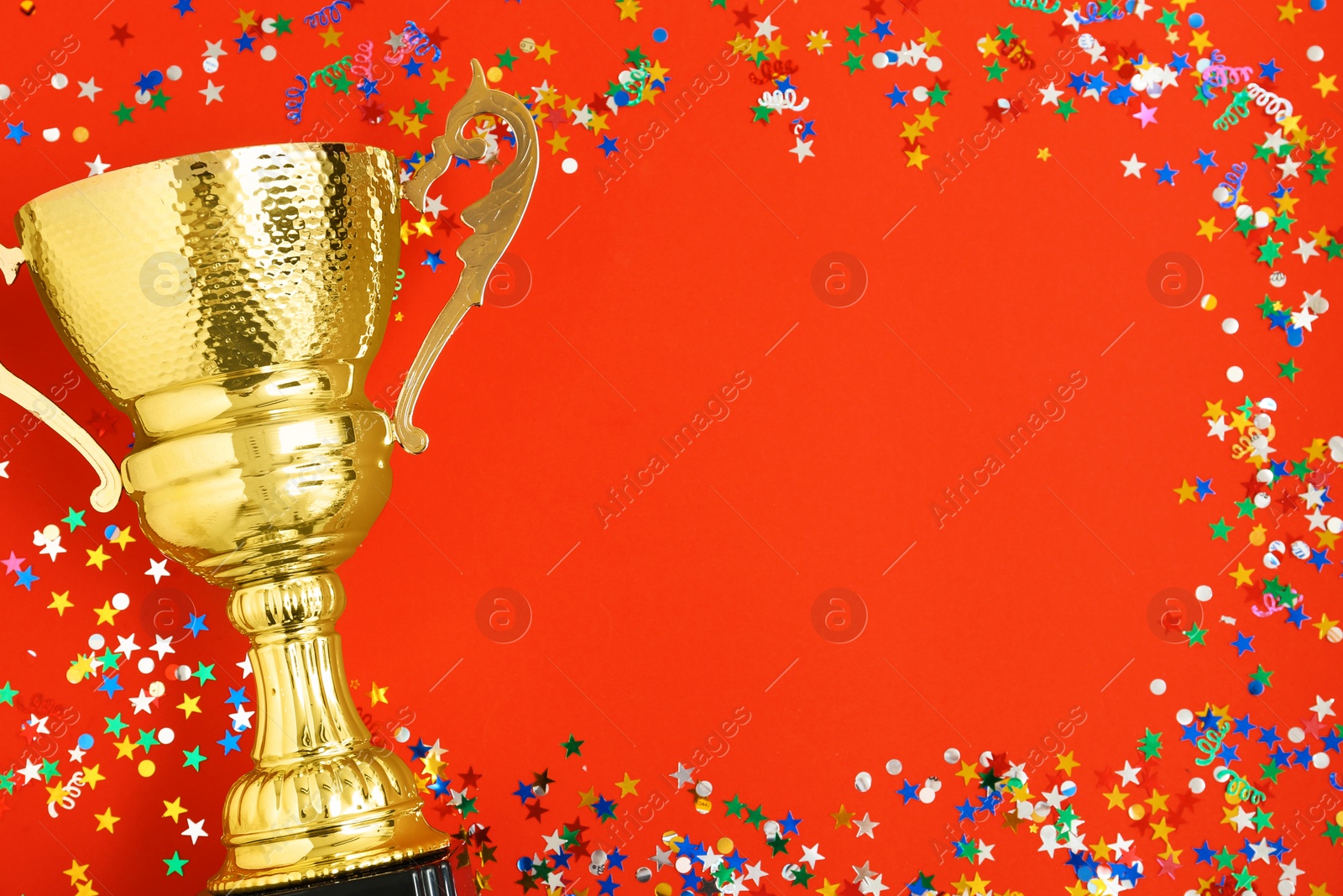 Photo of Trophy and frame of confetti on color background, top view with space for text. Victory concept