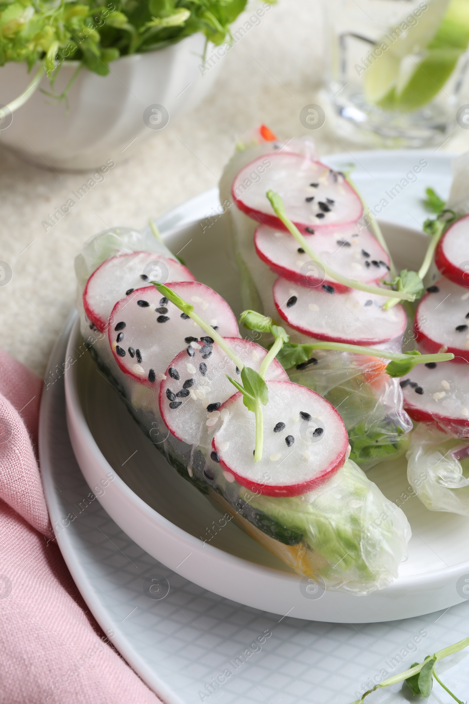 Photo of Delicious spring rolls wrapped in rice paper on table