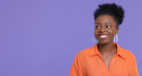 Photo of Portrait of happy young woman on purple background. Space for text
