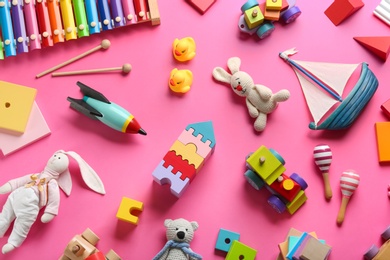 Flat lay composition with different toys on pink background