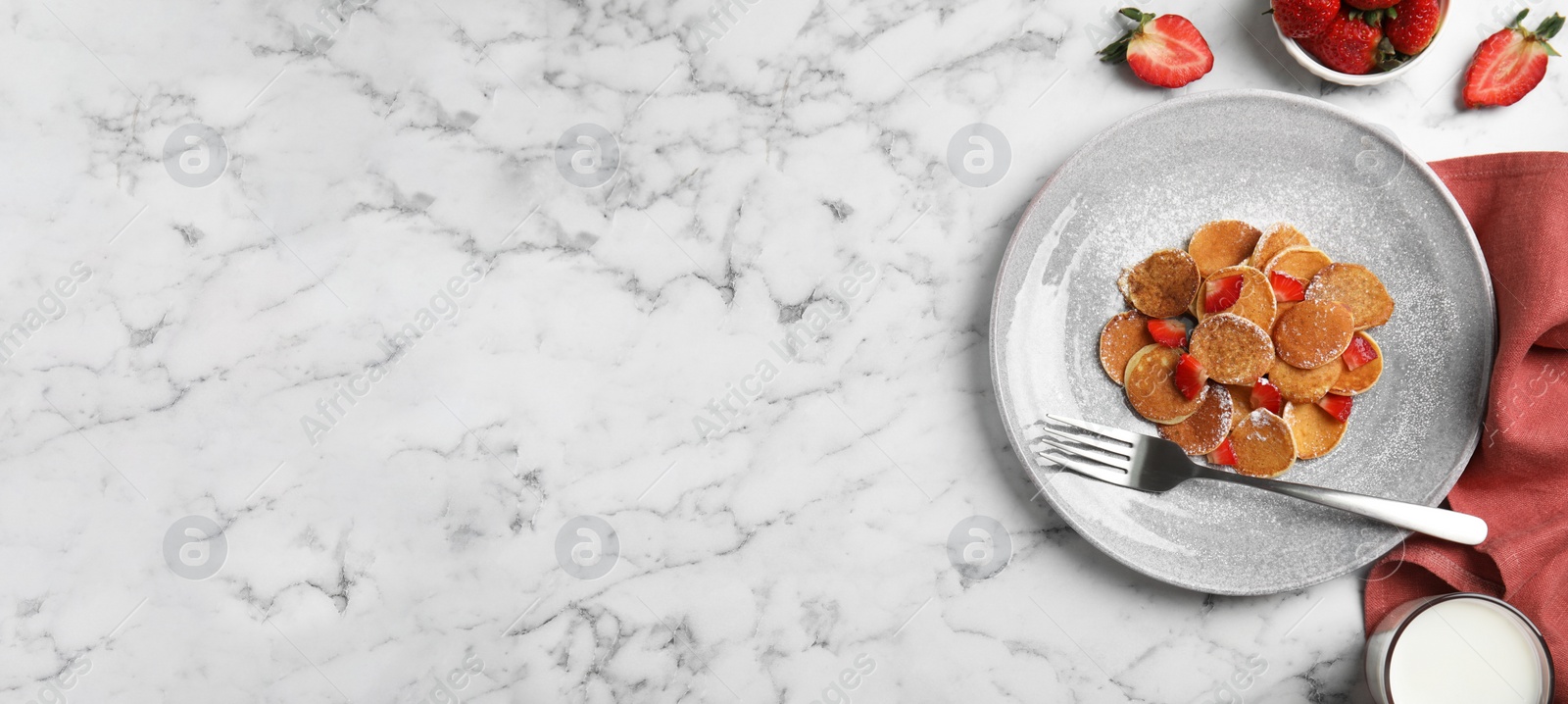 Image of Delicious mini pancakes cereal with strawberries served on white marble table, flat lay with space for text. Banner design