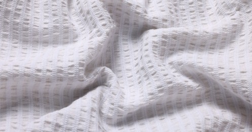 Photo of Texture of light crumpled fabric as background, closeup