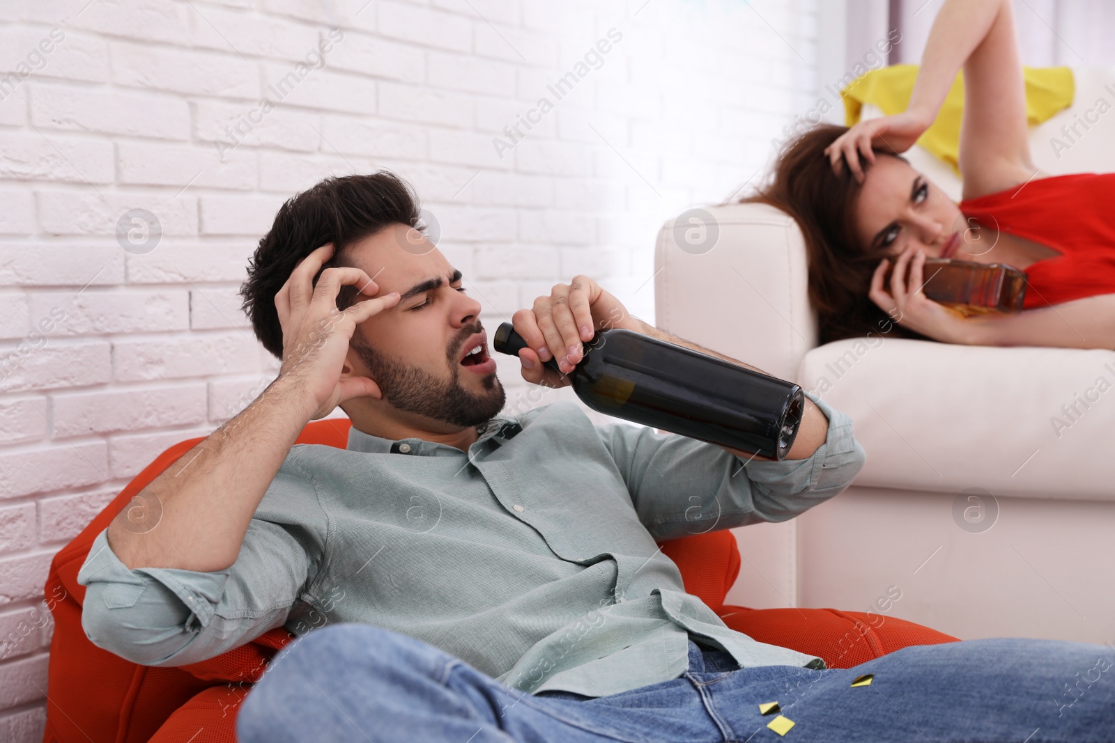 Photo of Friends suffering from hangover in messy room after party