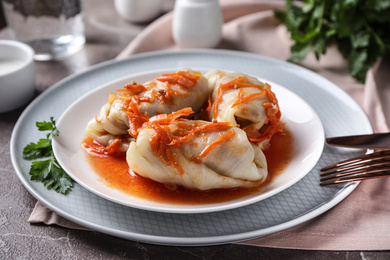 Photo of Delicious cabbage rolls served on grey marble table, closeup