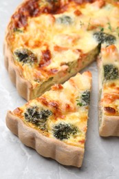 Photo of Delicious homemade quiche with salmon and broccoli on light gray table