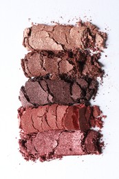 Photo of Different crushed eye shadows on white background, top view. Professional makeup product