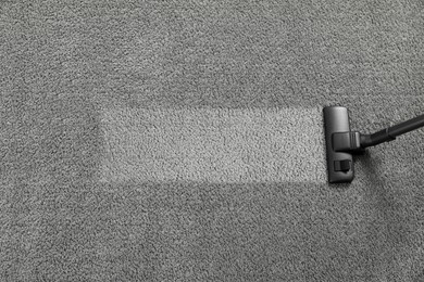 Vacuuming grey carpet. Clean area after using device, top view. Space for text