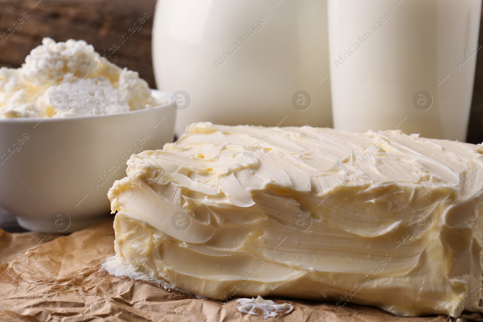 Photo of Tasty homemade butter and dairy products on parchment, closeup