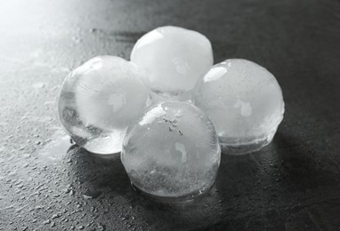 Photo of Melting ice balls on dark grey table