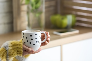 Photo of Woman with cup of coffee indoors, closeup