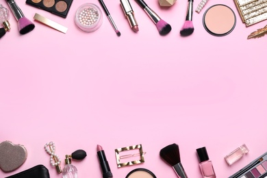 Photo of Makeup brushes and cosmetic products on pink background, flat lay. Space for text