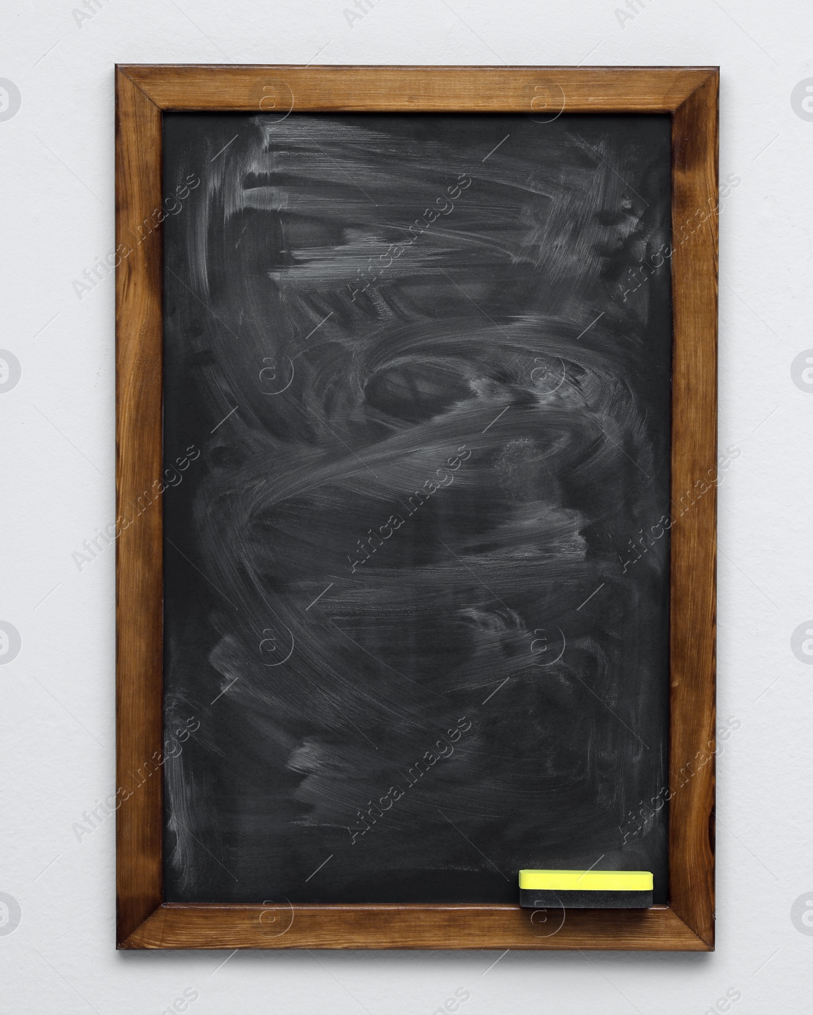 Photo of Dirty black chalkboard hanging on grey wall