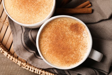 Delicious eggnog with cinnamon on wooden table, top view