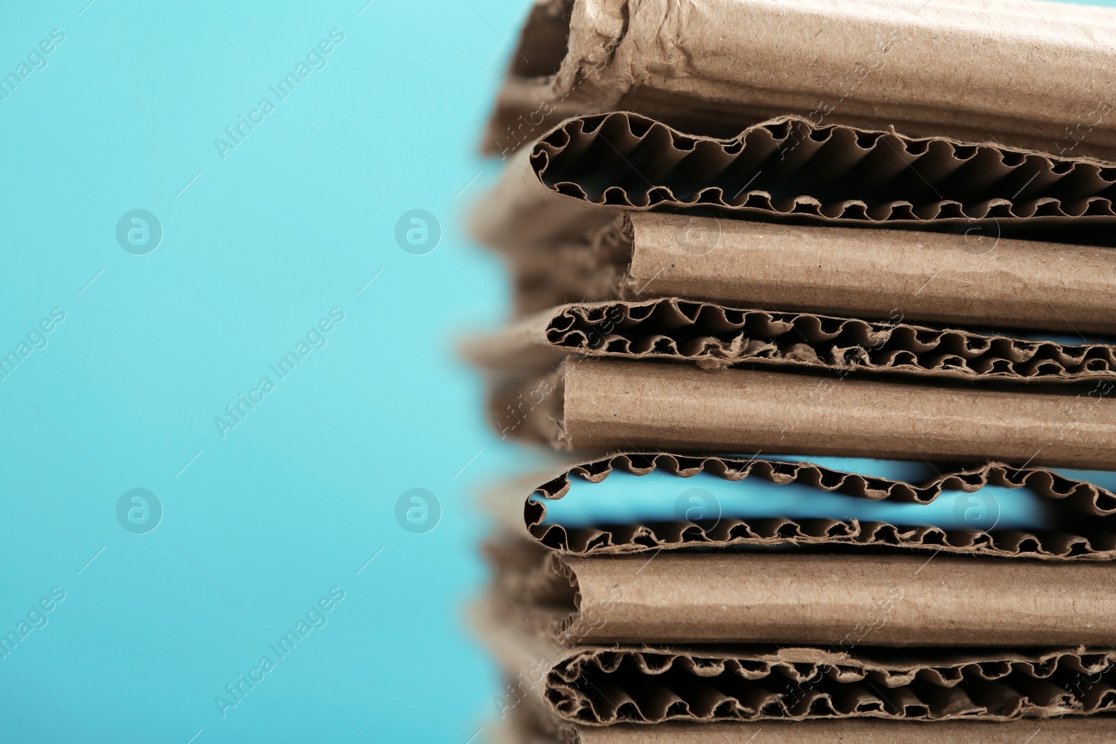 Photo of Stack of cardboard for recycling on color background, closeup. Space for text