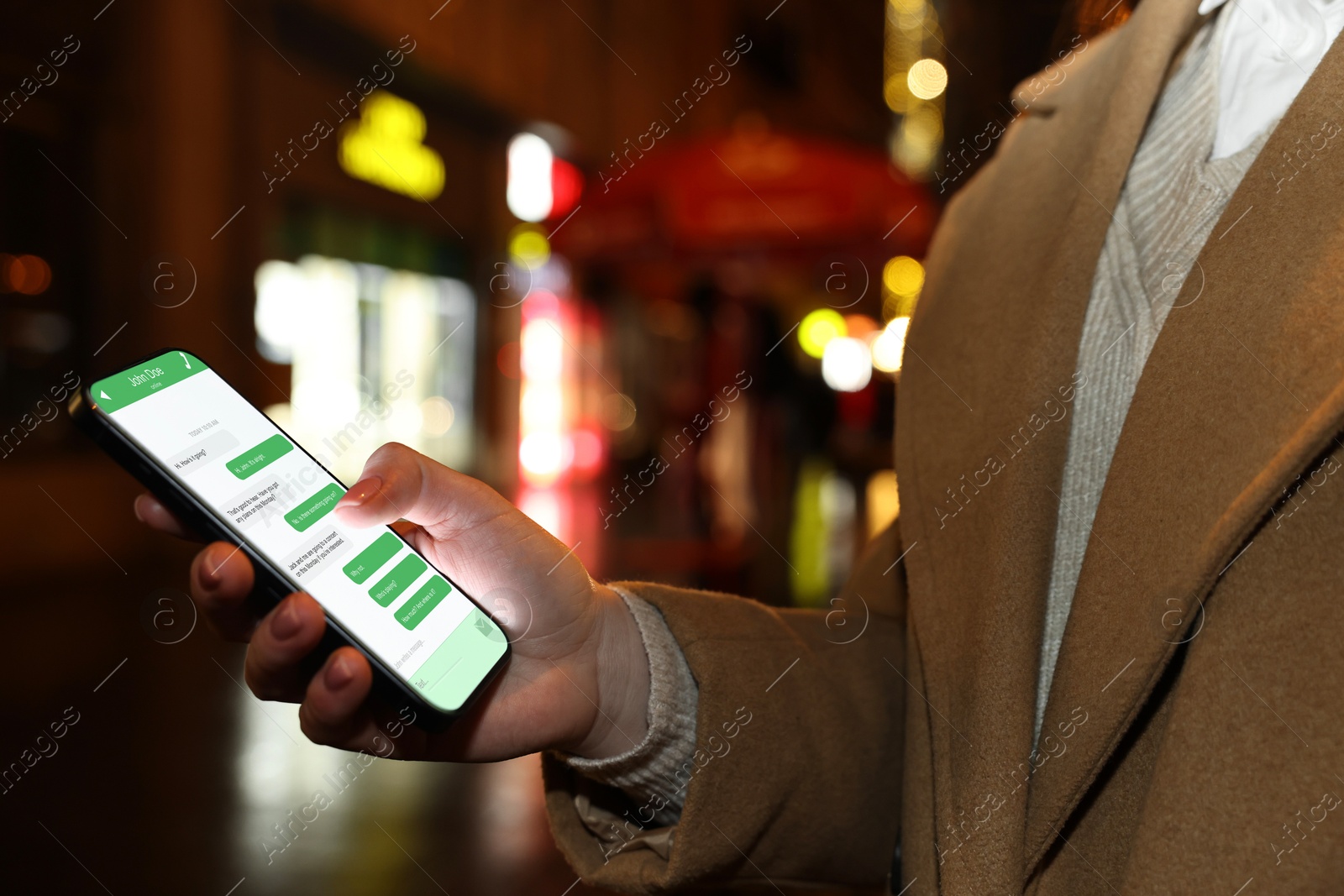 Image of Woman texting via mobile phone outdoors, closeup. Device screen with messages