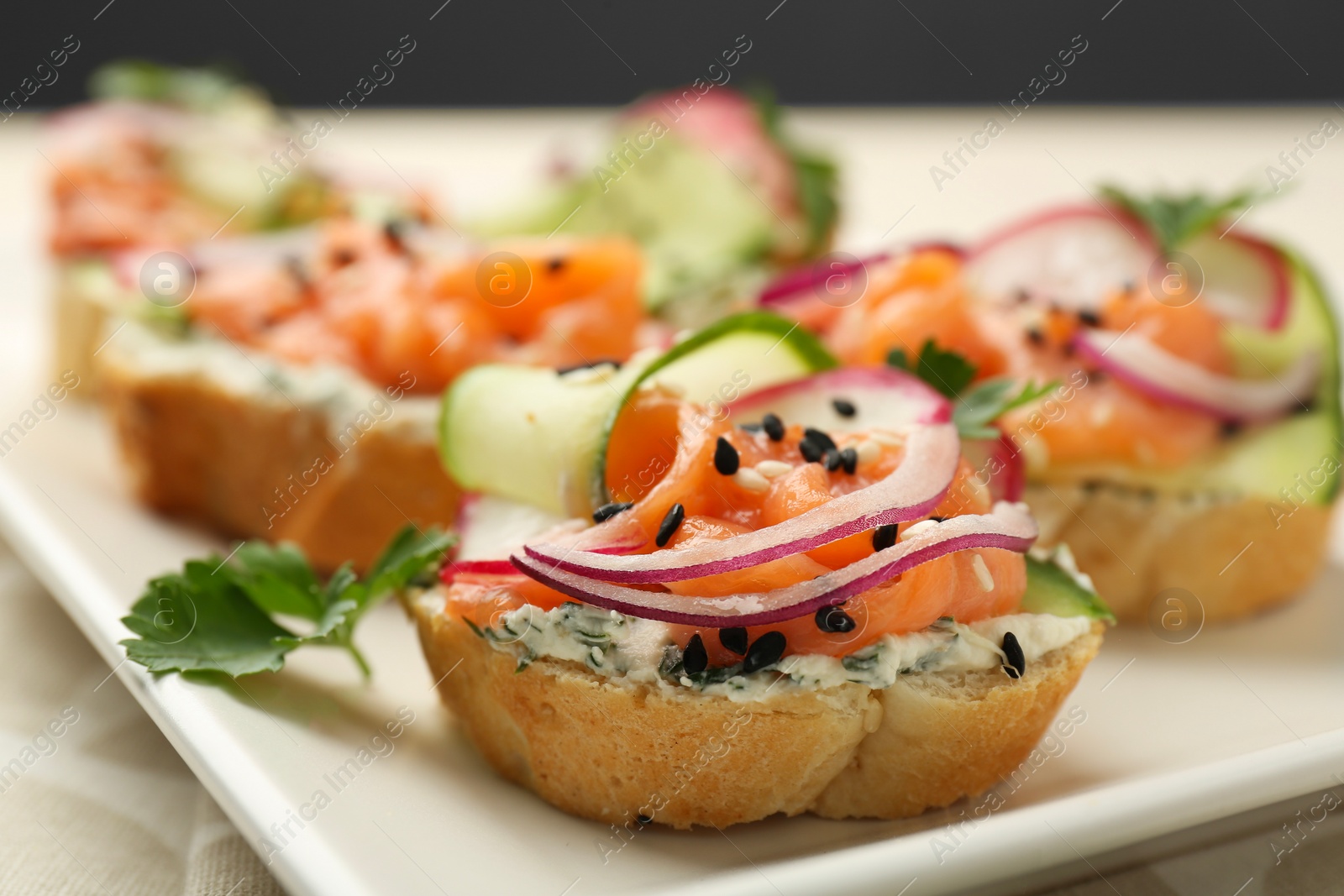 Photo of Tasty canapes with salmon served on table, closeup