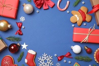 Frame made with Christmas decor on blue background, flat lay. Space for text