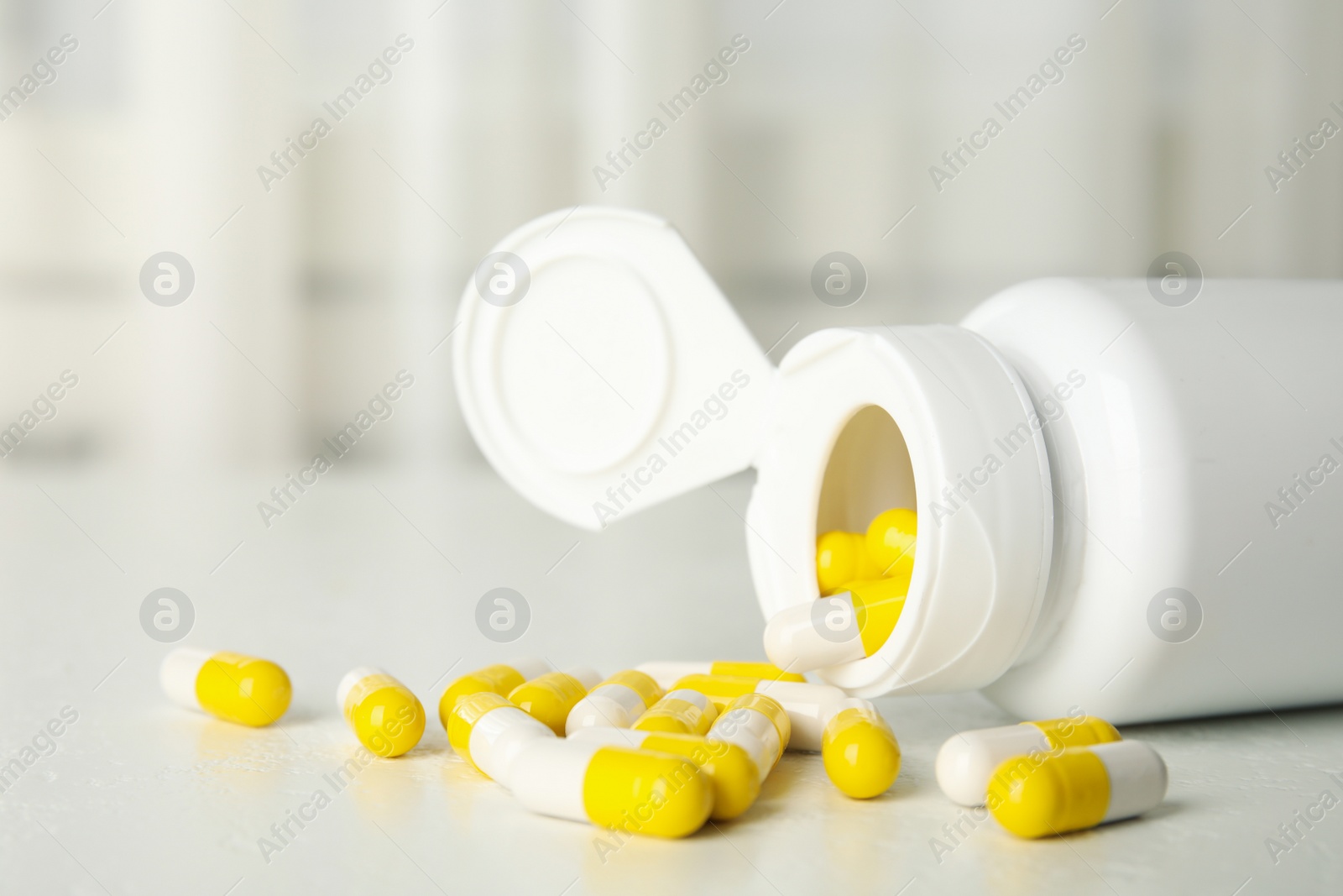 Photo of Bottle with vitamin pills on white table, closeup