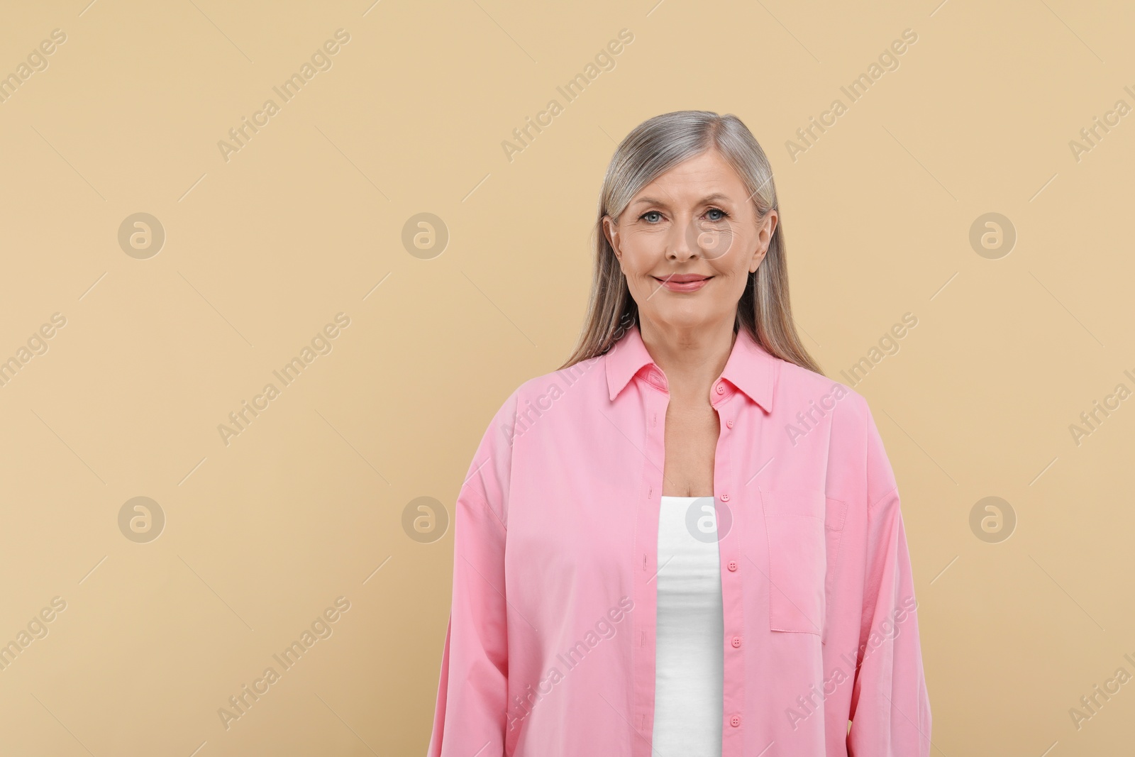 Photo of Portrait of beautiful senior woman on beige background. Space for text