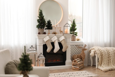 Photo of Fireplace in room with Christmas decorations. Interior design