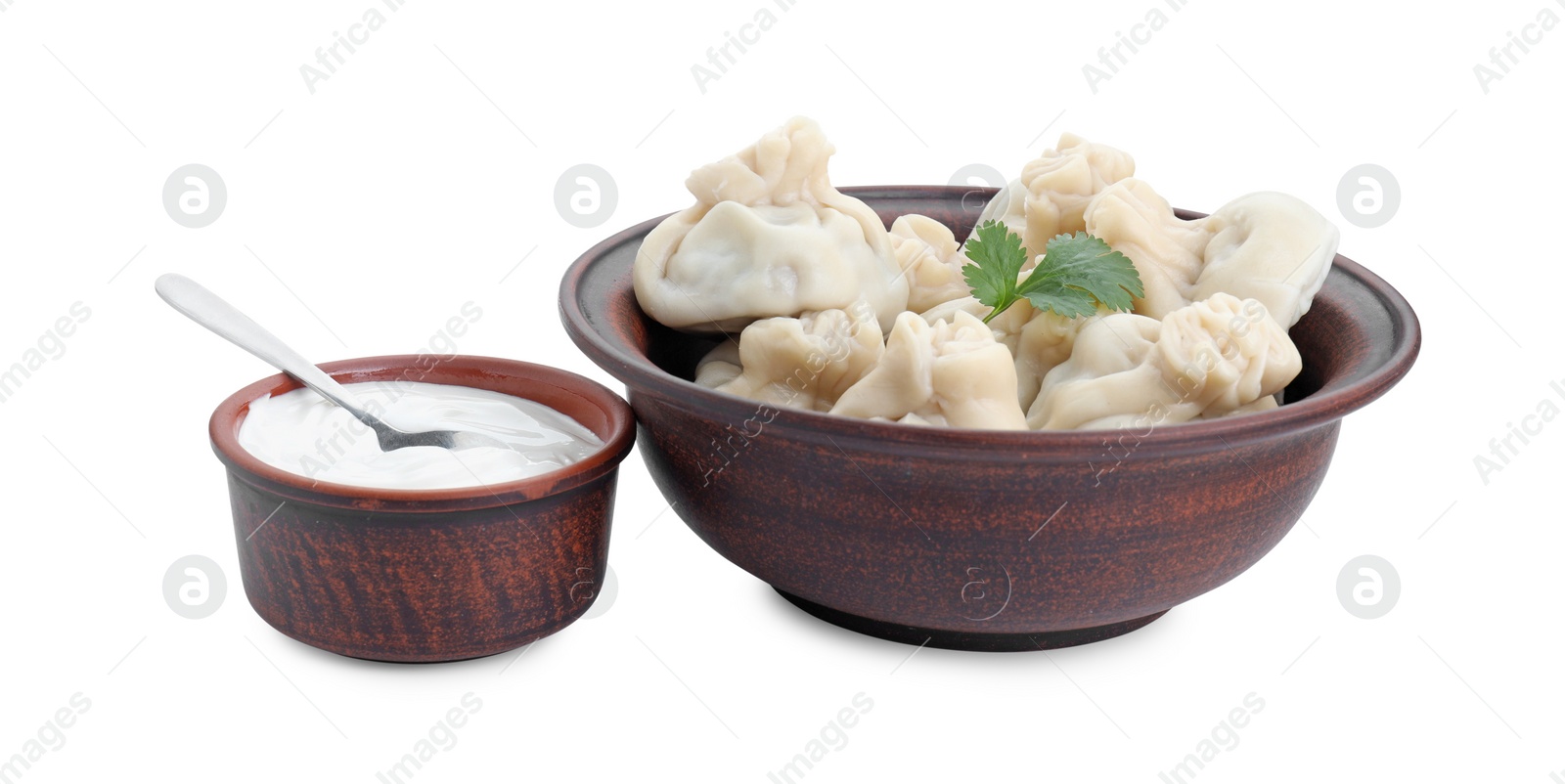 Photo of Tasty khinkali (dumplings) with sauce and parsley isolated on white. Georgian cuisine