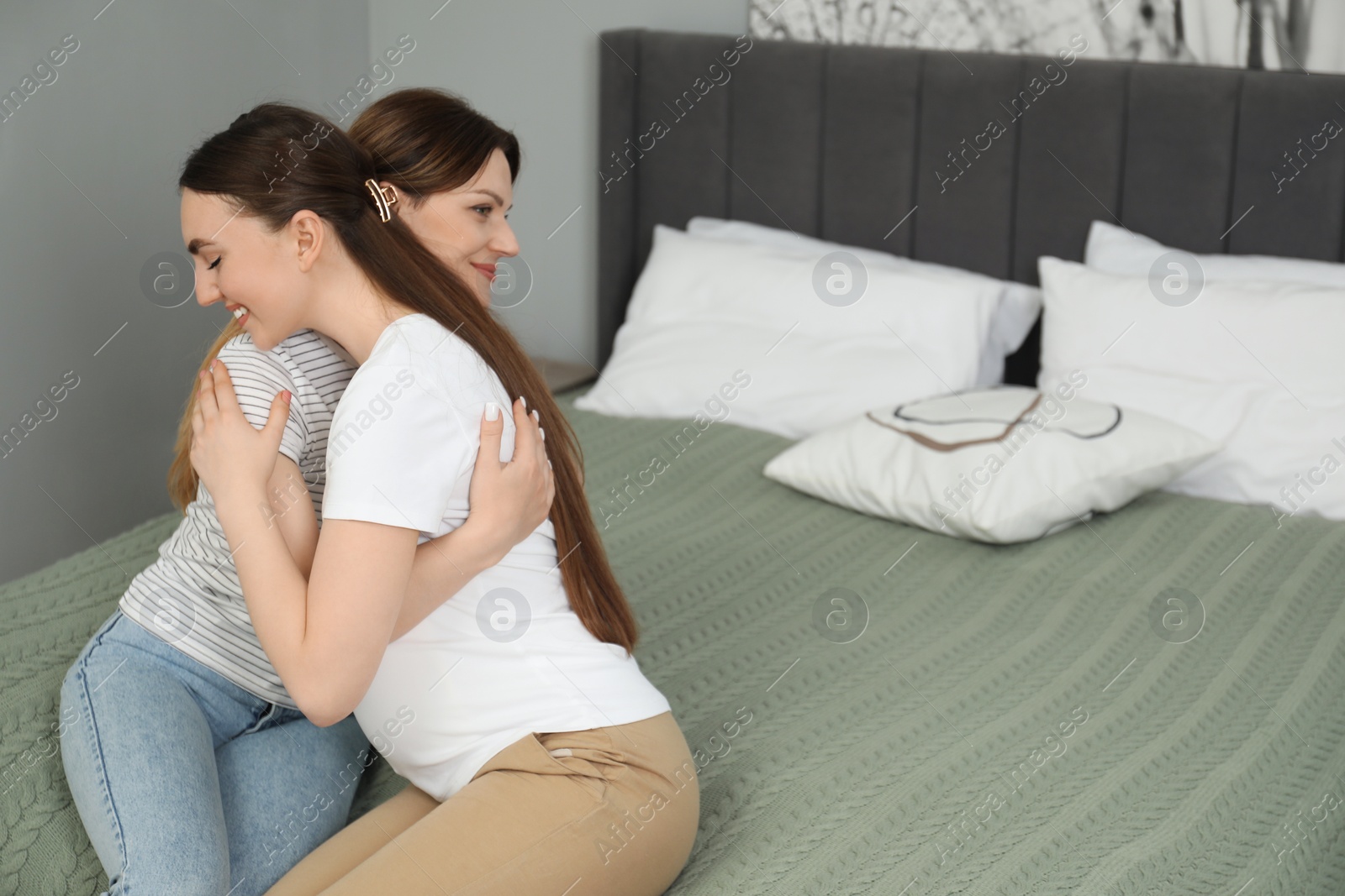Photo of Doula hugging pregnant woman in bedroom. Preparation for child birth