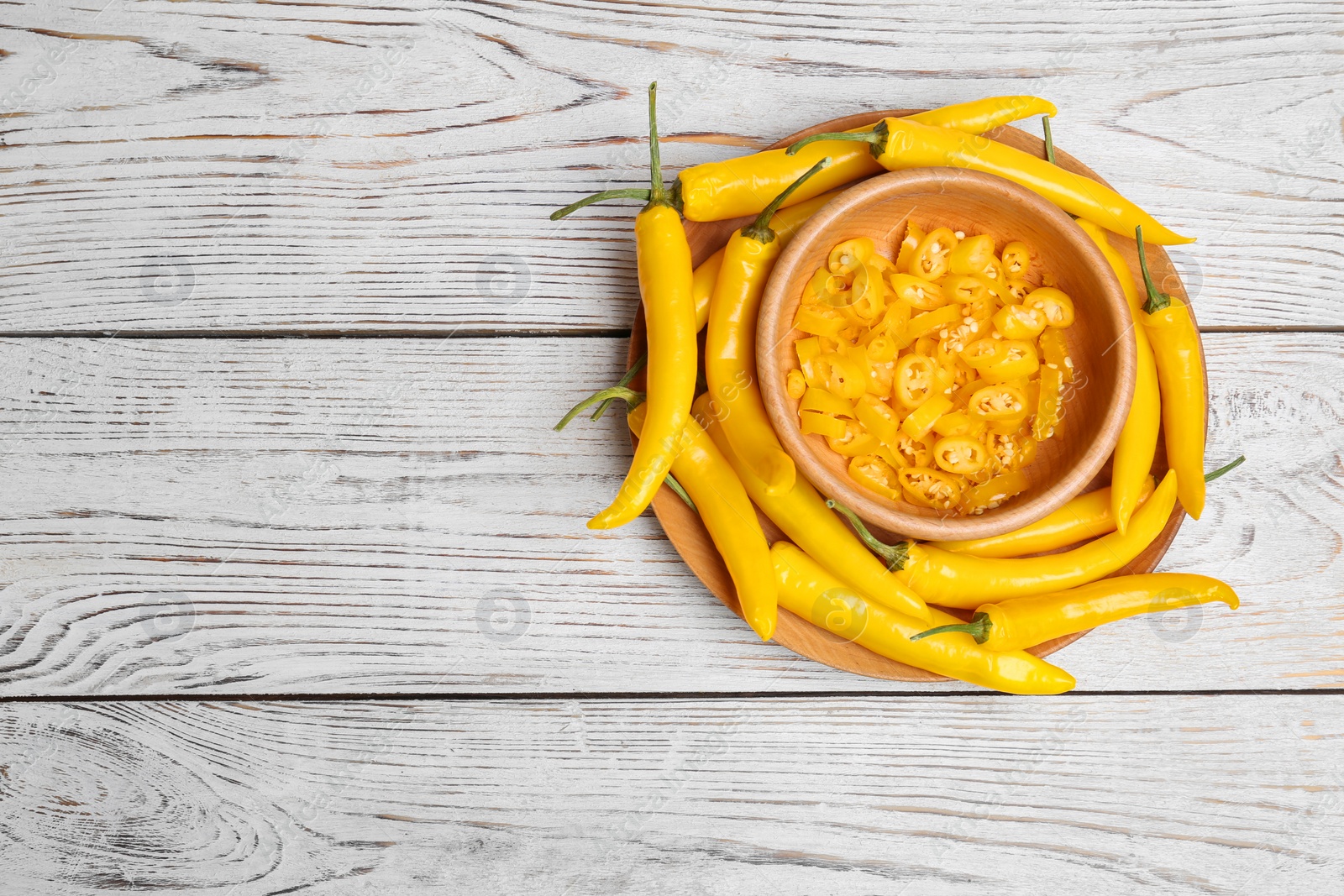 Photo of Dishware with chili peppers on wooden background, top view