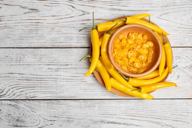 Photo of Dishware with chili peppers on wooden background, top view