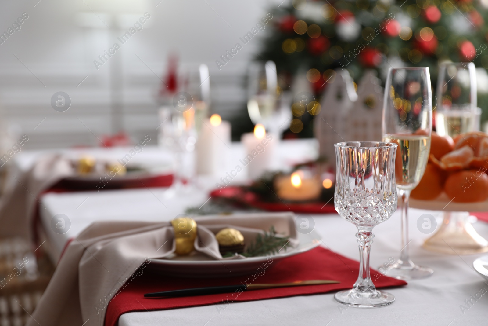 Photo of Christmas table setting with beautiful napkin, cutlery and dishware indoors