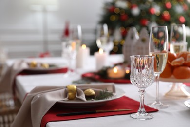 Photo of Christmas table setting with beautiful napkin, cutlery and dishware indoors