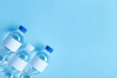 Bottles of water on color background, top view. Space for text